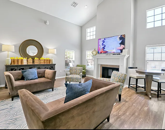 Bright and inviting living room with modern decor, plush sofas, stylish armchairs, and a cozy fireplace. Perfect for relaxation and entertaining.