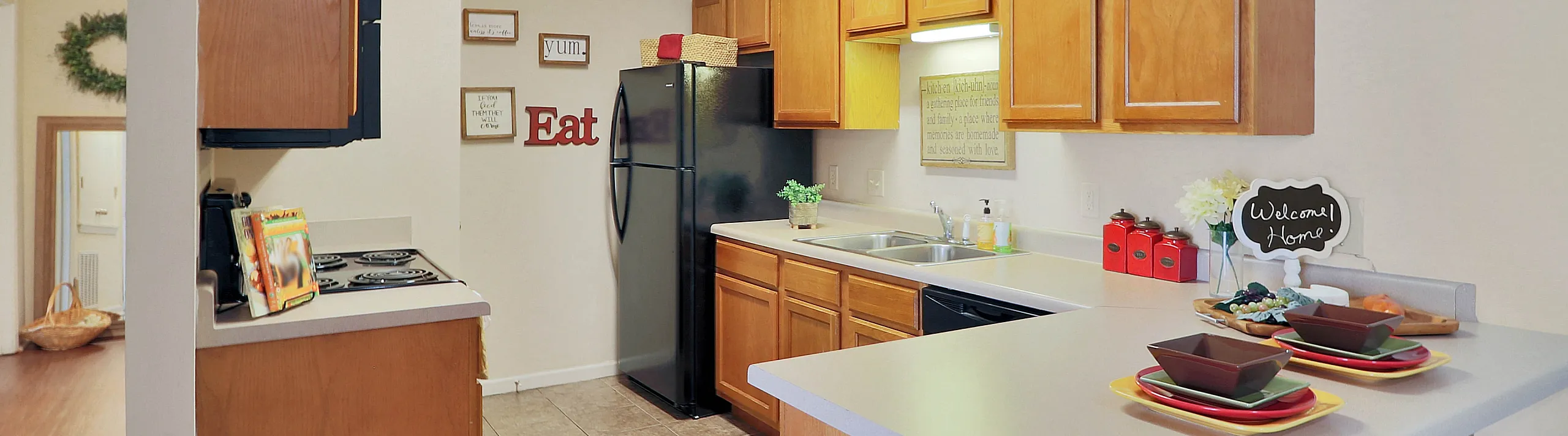 Inviting kitchen with warm wooden cabinetry, modern appliances, and cozy bar seating for two.