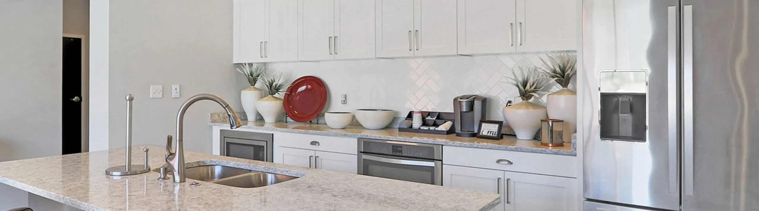Contemporary kitchen with sleek countertops, modern stainless steel appliances, and elegant pendant lighting.