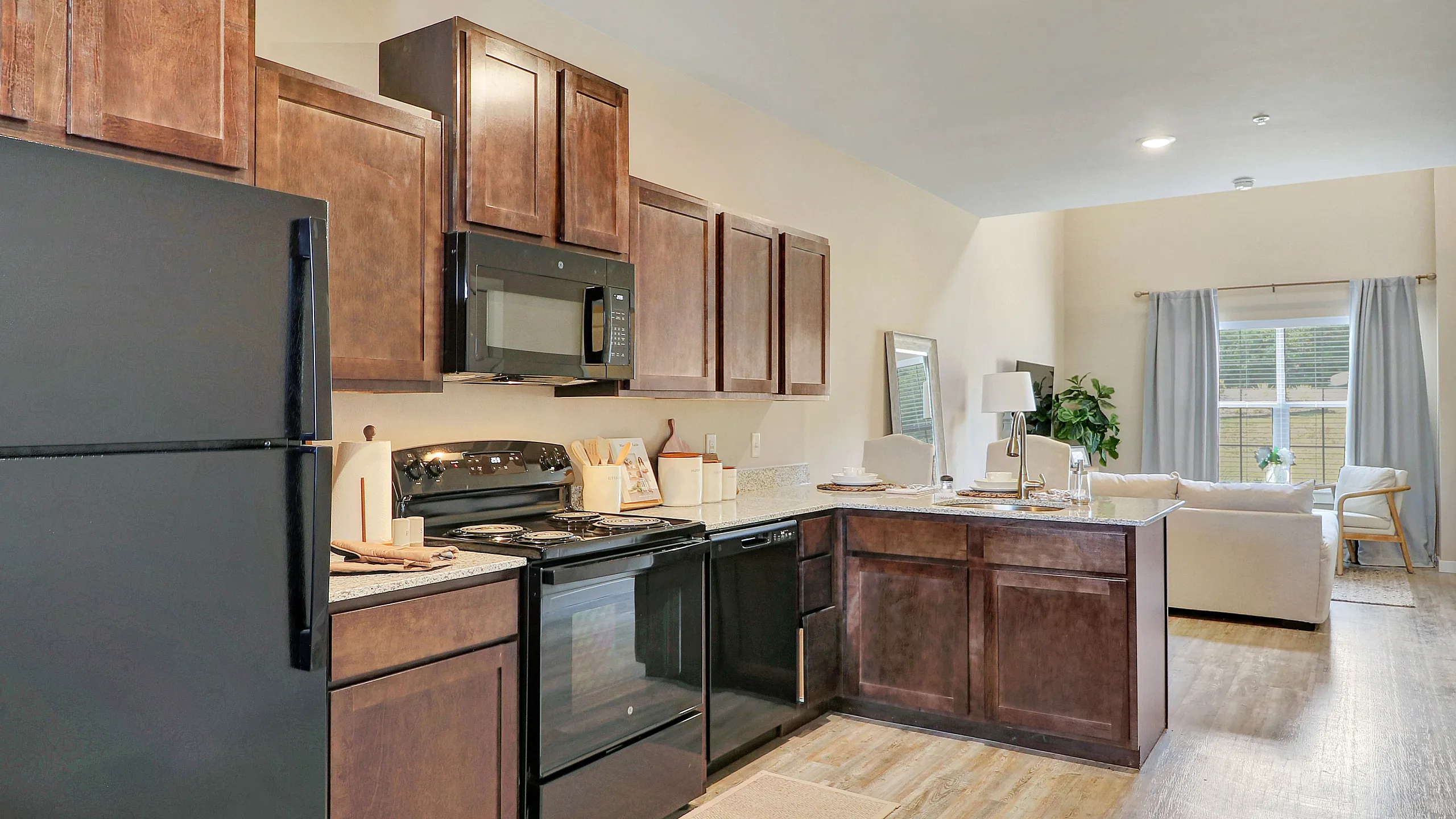 Beautifully designed open-concept kitchen and living area with modern appliances, warm wooden cabinetry, and elegant decor.