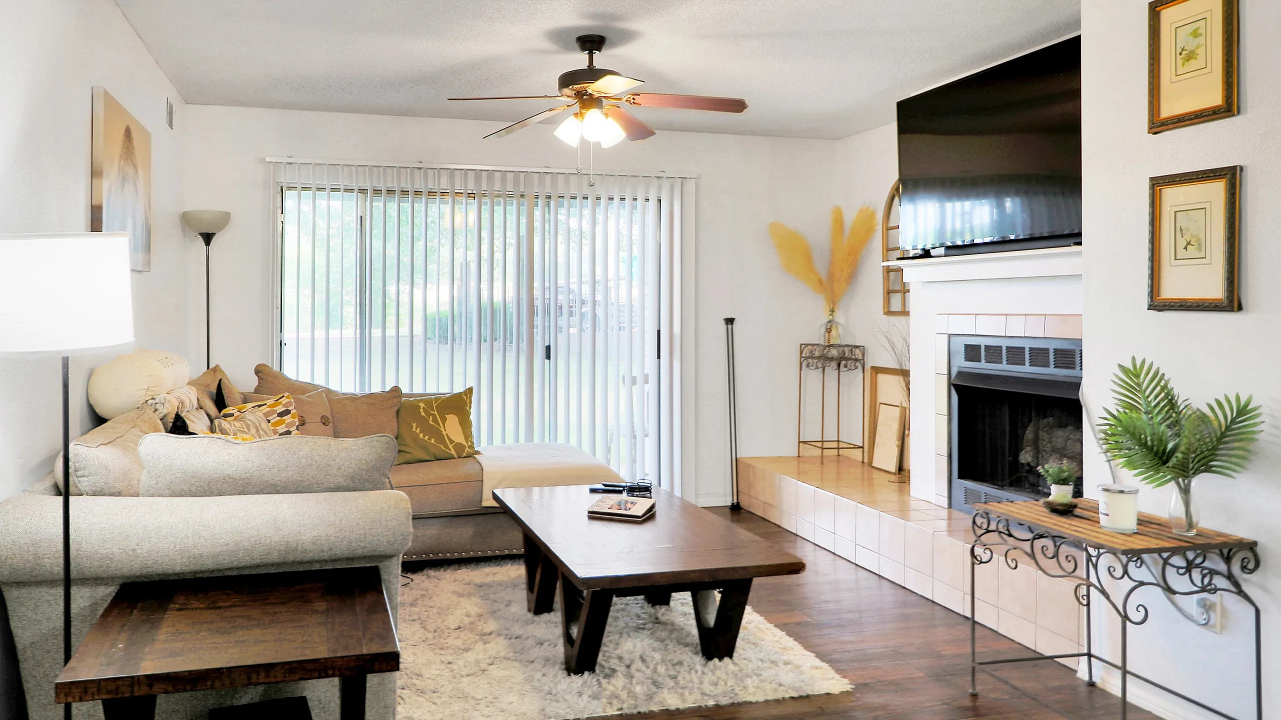 Bright and cozy living room with plush sectional sofa, stylish coffee table, and a modern fireplace under a mounted TV. Enjoy natural light through expansive sliding doors with garden view.