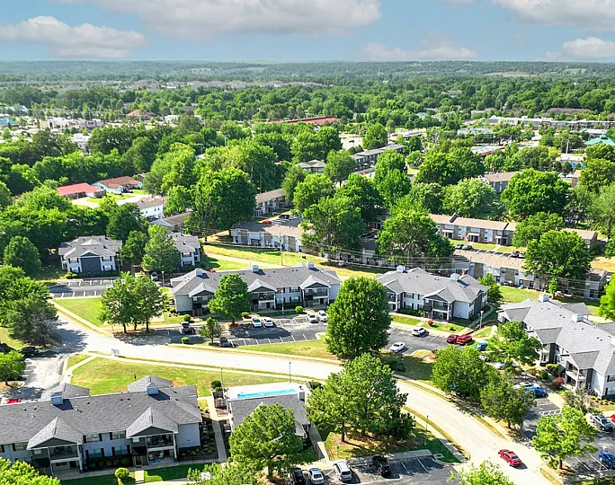 Scenic aerial view of a vibrant residential community with lush greenery and well-maintained streets, offering a tranquil and picturesque living environment.