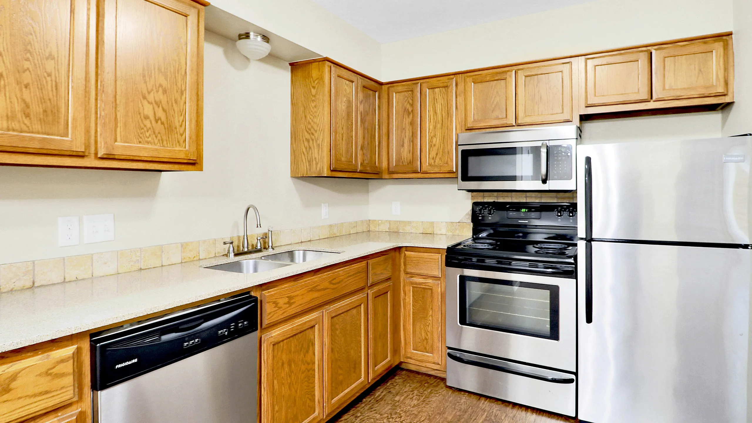 Modern kitchen with sleek stainless steel appliances, elegant wooden cabinetry, and a spacious countertop.