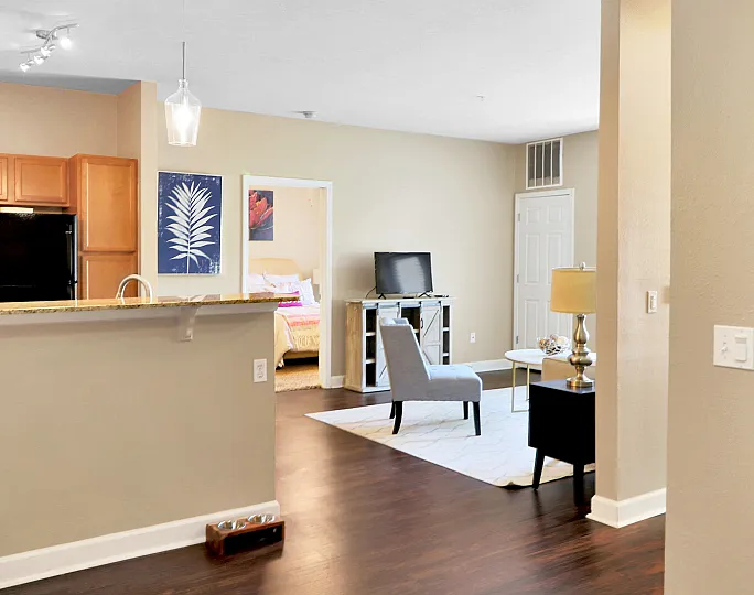Inviting open-concept living area with sleek hardwood floors, modern kitchen, and cozy seating, perfect for relaxation.