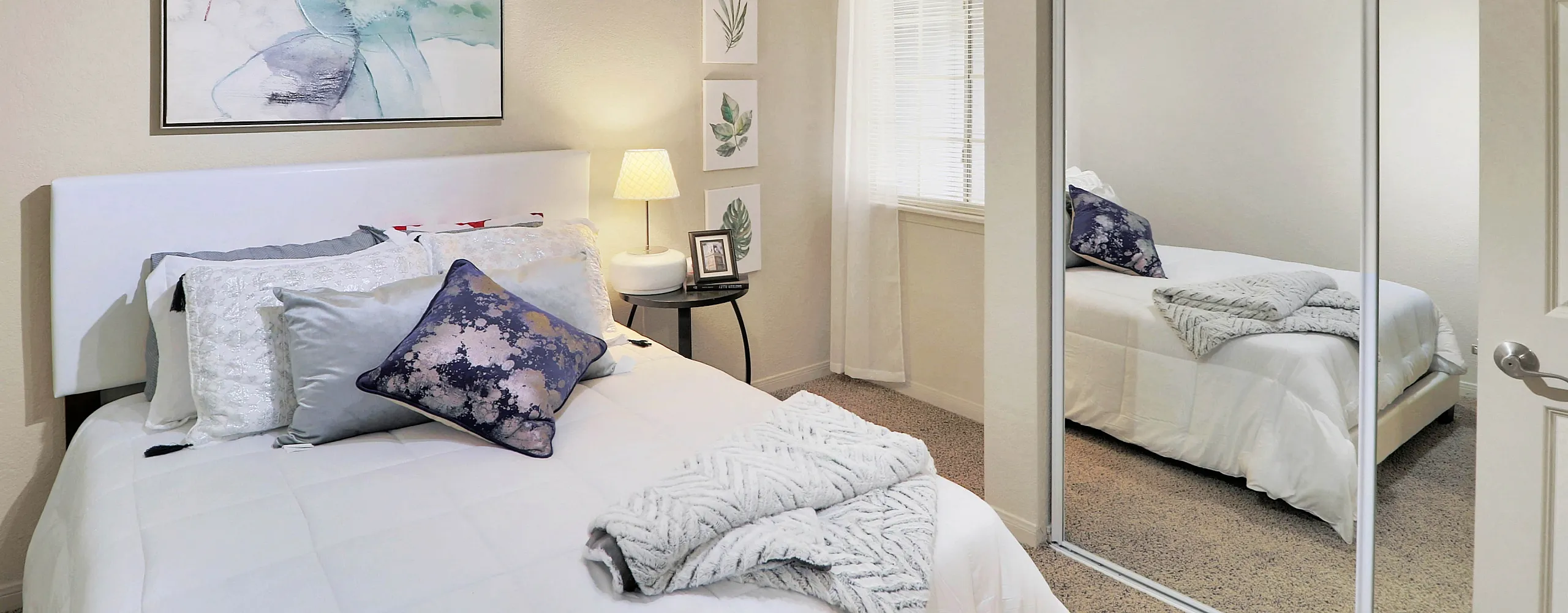 Charming bedroom with cozy bed, elegant decor, and mirrored closet, offering a serene and inviting atmosphere.