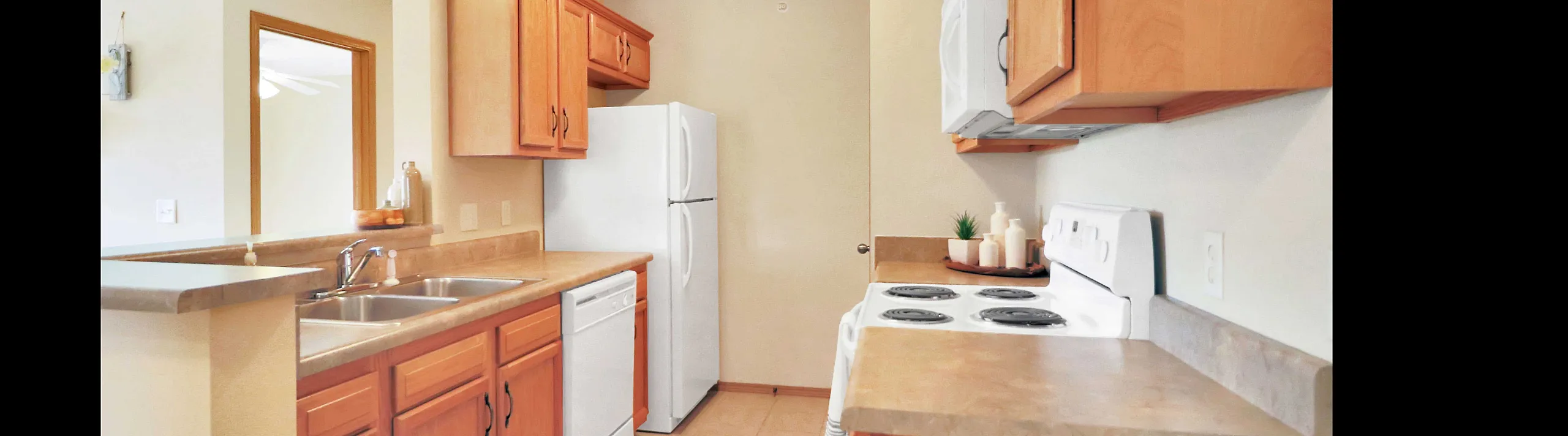 Bright, welcoming kitchen with modern appliances, stylish wooden cabinetry, and ample counter space.