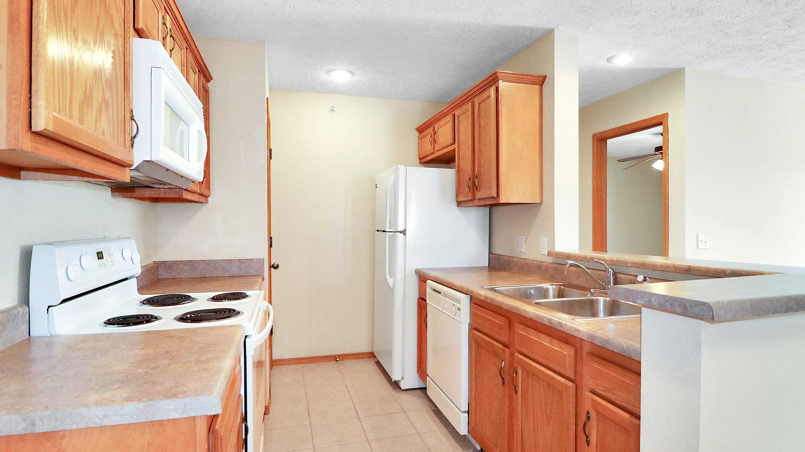 Bright and inviting kitchen with modern appliances, wooden cabinetry, and a spacious countertop, perfect for culinary creativity.