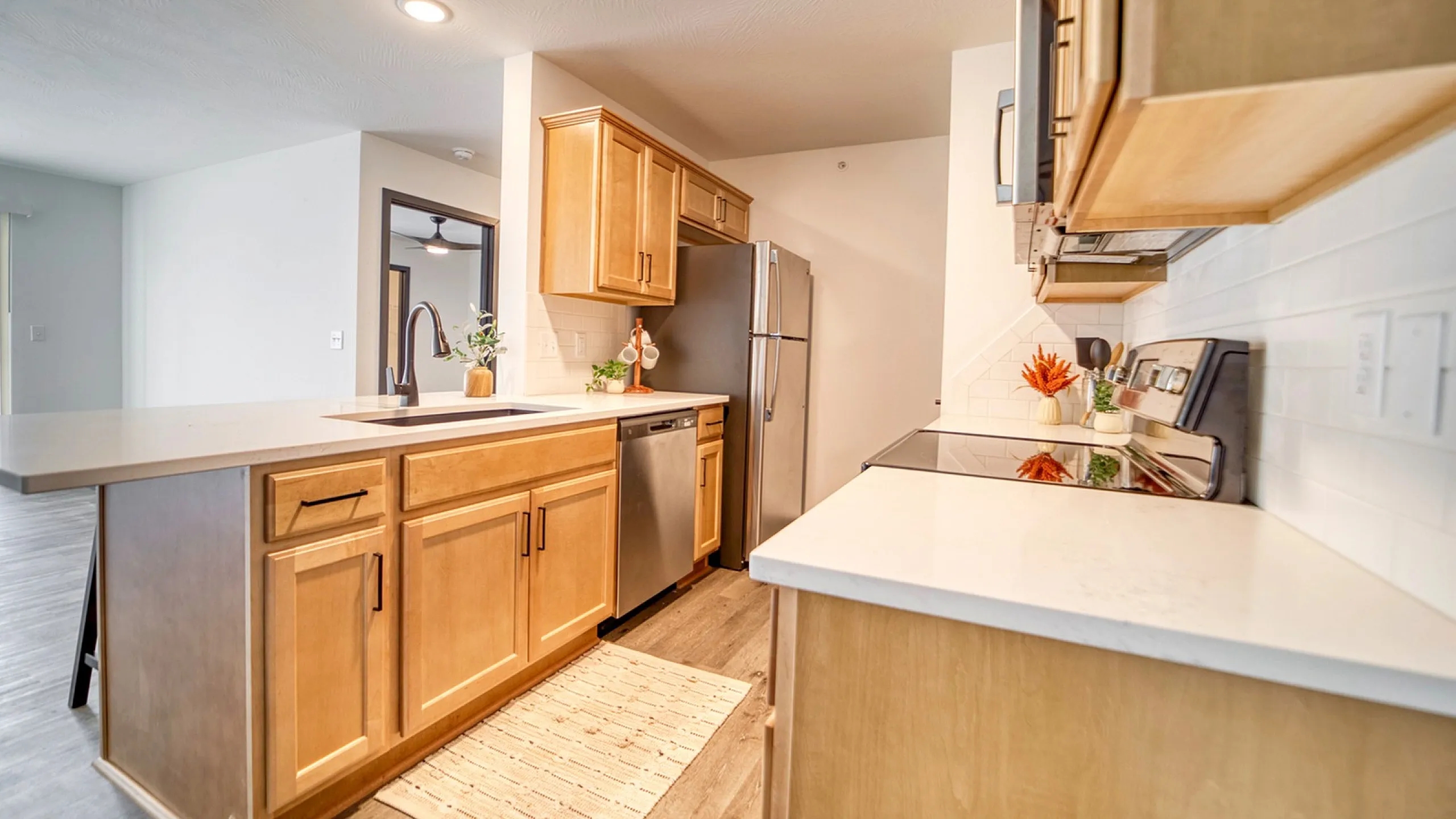 Modern kitchen featuring sleek wooden cabinets, stainless steel appliances, and elegant countertops, exuding a warm and inviting ambiance.