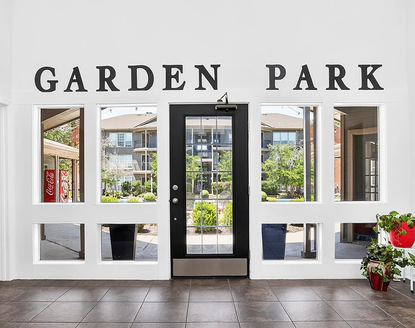 Welcome to Garden Park entrance showcasing bright natural light, lush greenery, and modern design.