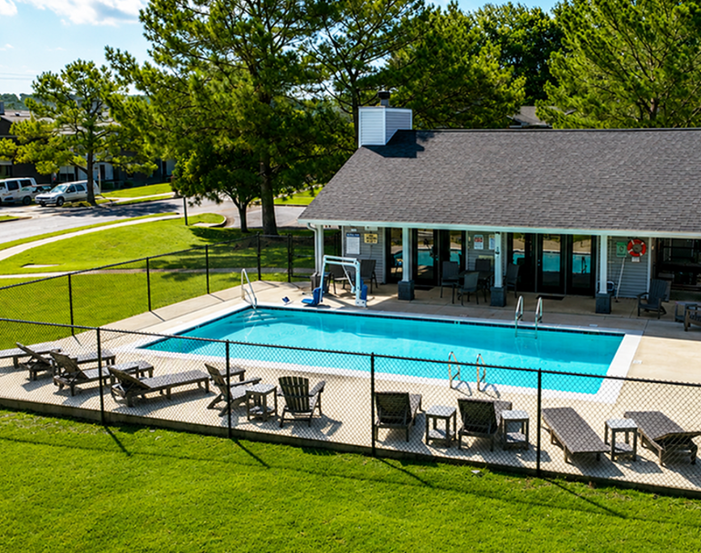 Inviting outdoor swimming pool area with sun loungers and lush green surroundings, perfect for relaxation and leisure.