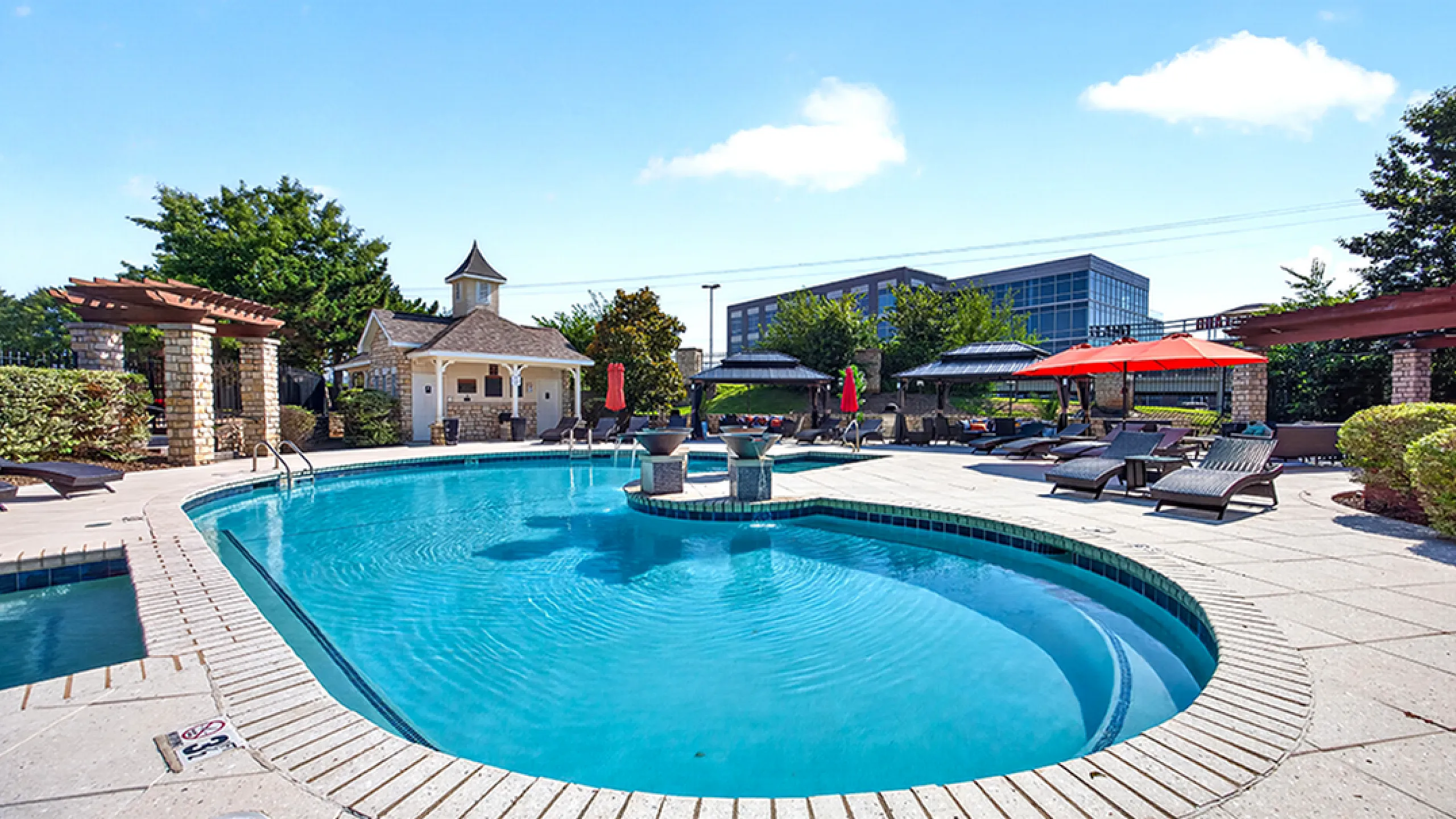 Stunning resort-style pool with elegant lounge area and lush greenery, perfect for relaxation and luxury living.