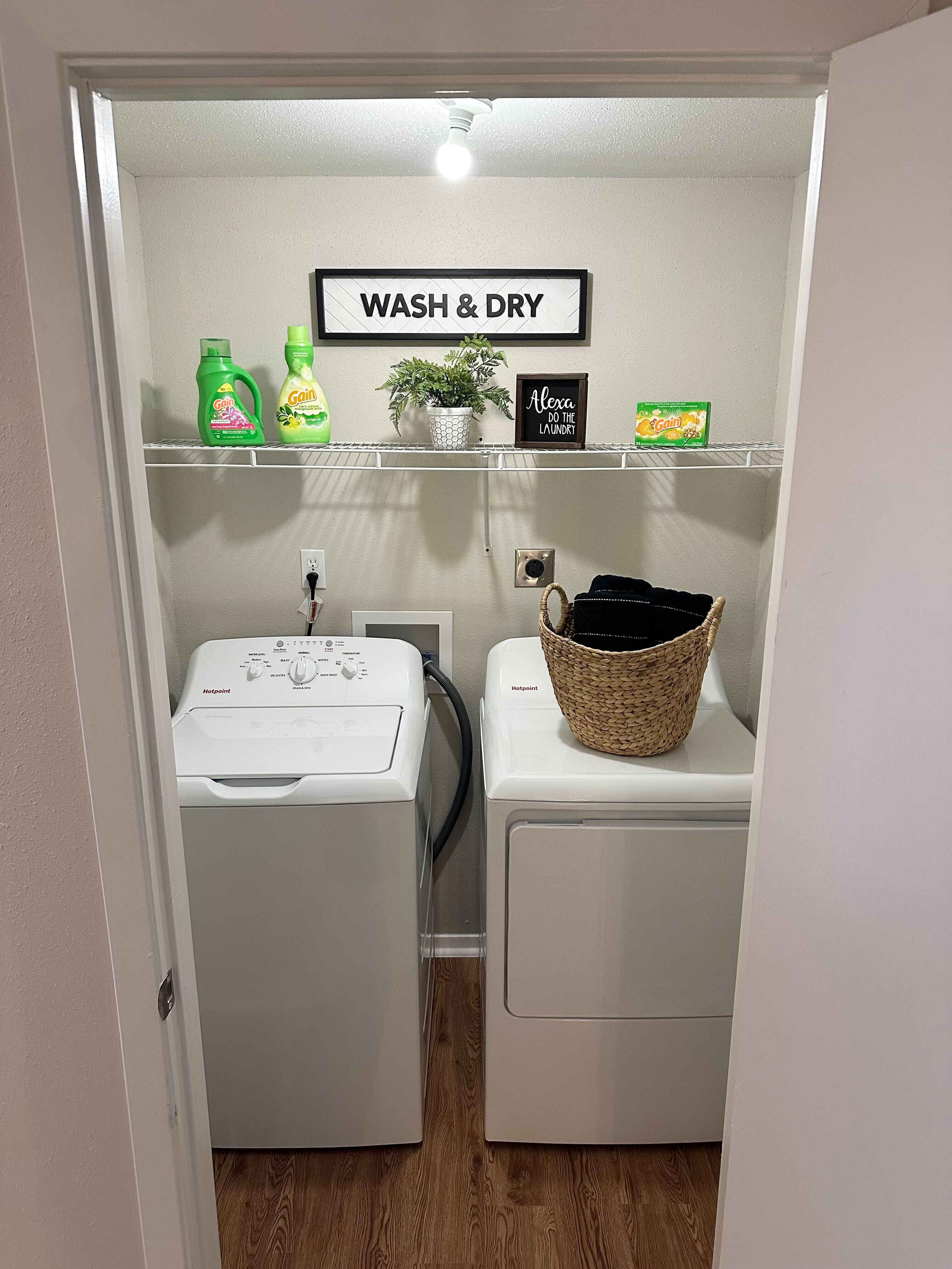 Chic laundry room with modern appliances, wooden flooring, and stylish storage solutions.