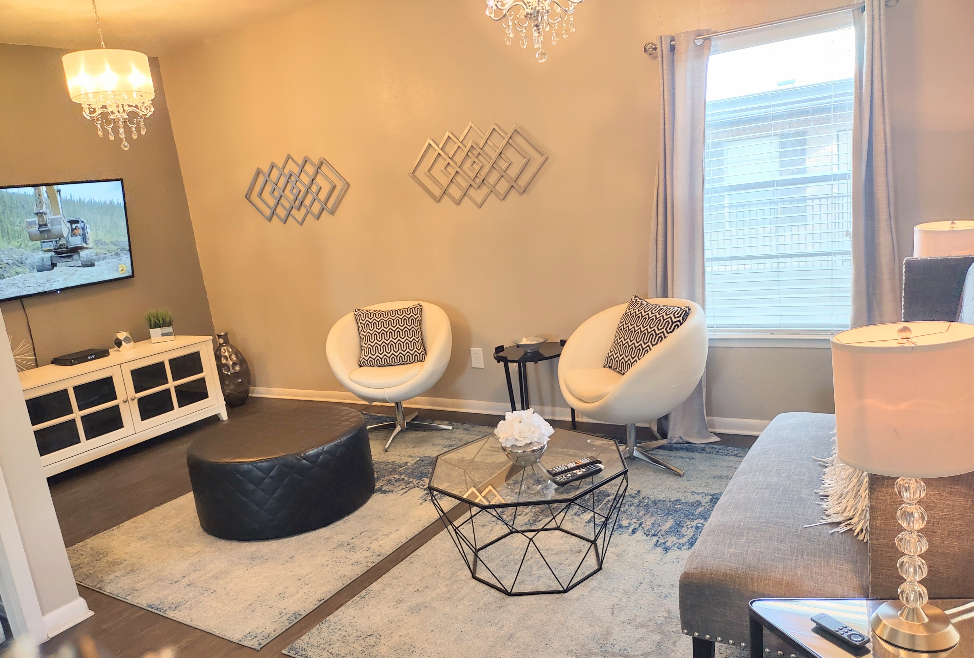 Chic living room with elegant decor, featuring modern furniture, a plush rug, and ambient lighting.