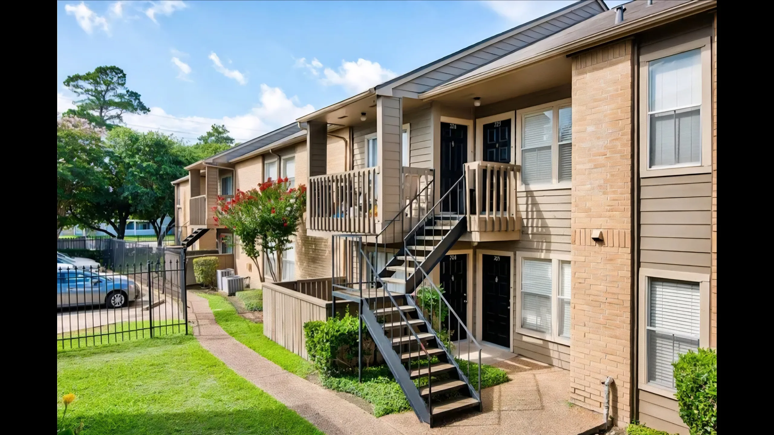 Charming apartment complex with lush greenery and inviting pathways, featuring modern balconies and a serene atmosphere.