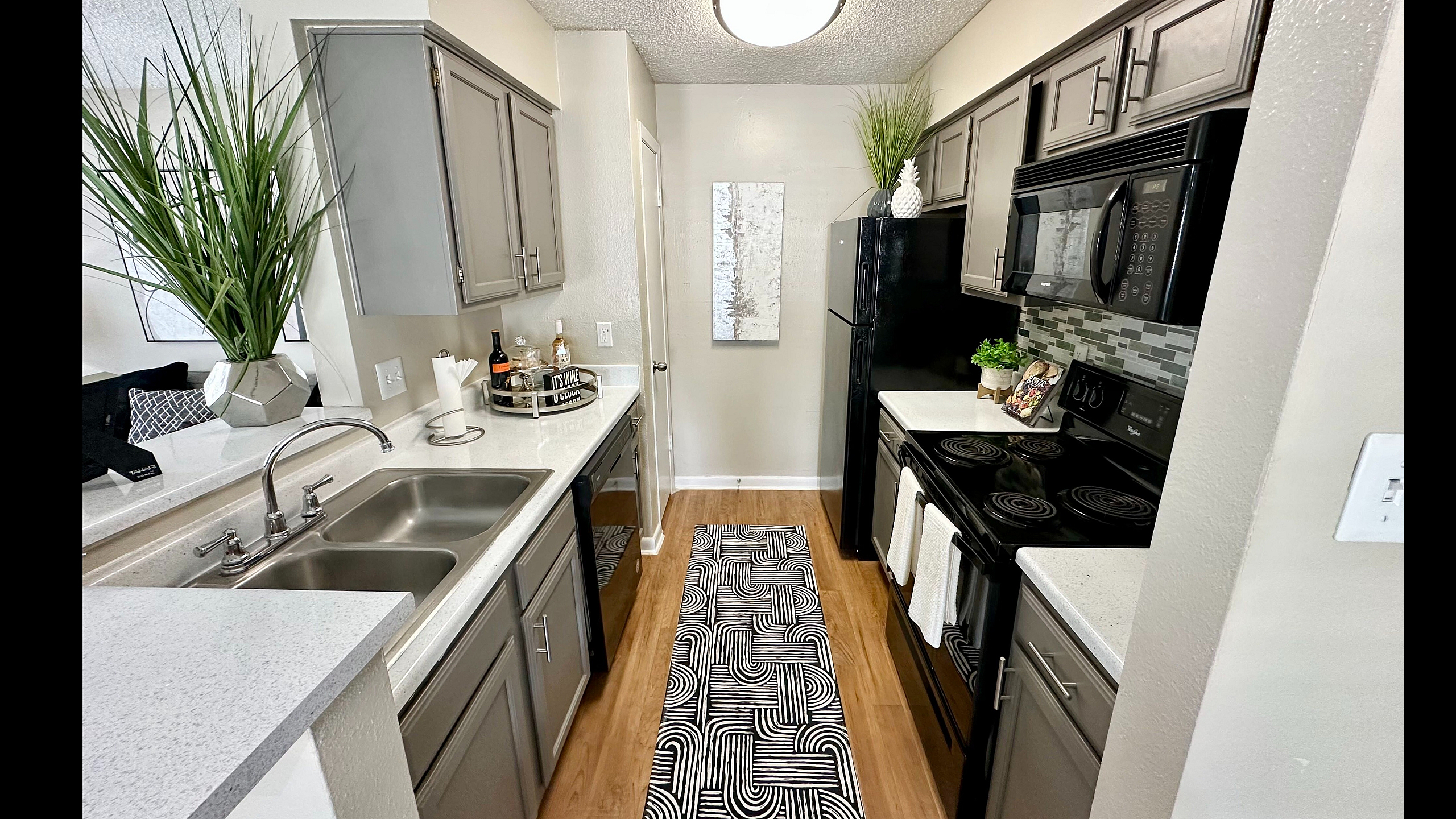 Modern kitchen with sleek gray cabinetry, stainless steel appliances, stylish countertop, and elegant decorative accents.