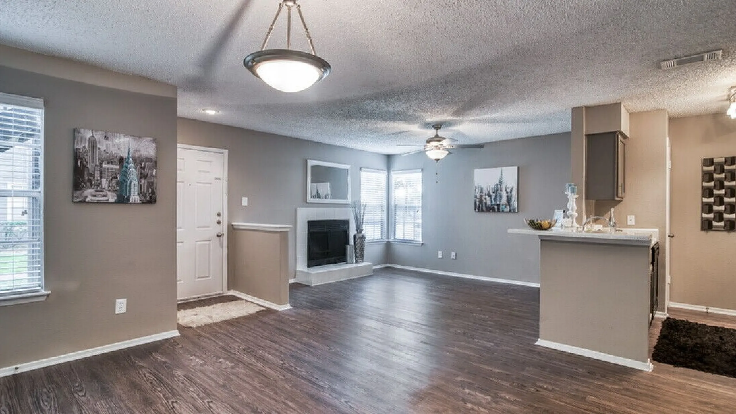 Bright and airy open-concept living room with modern hardwood floors, a cozy fireplace, and contemporary lighting.