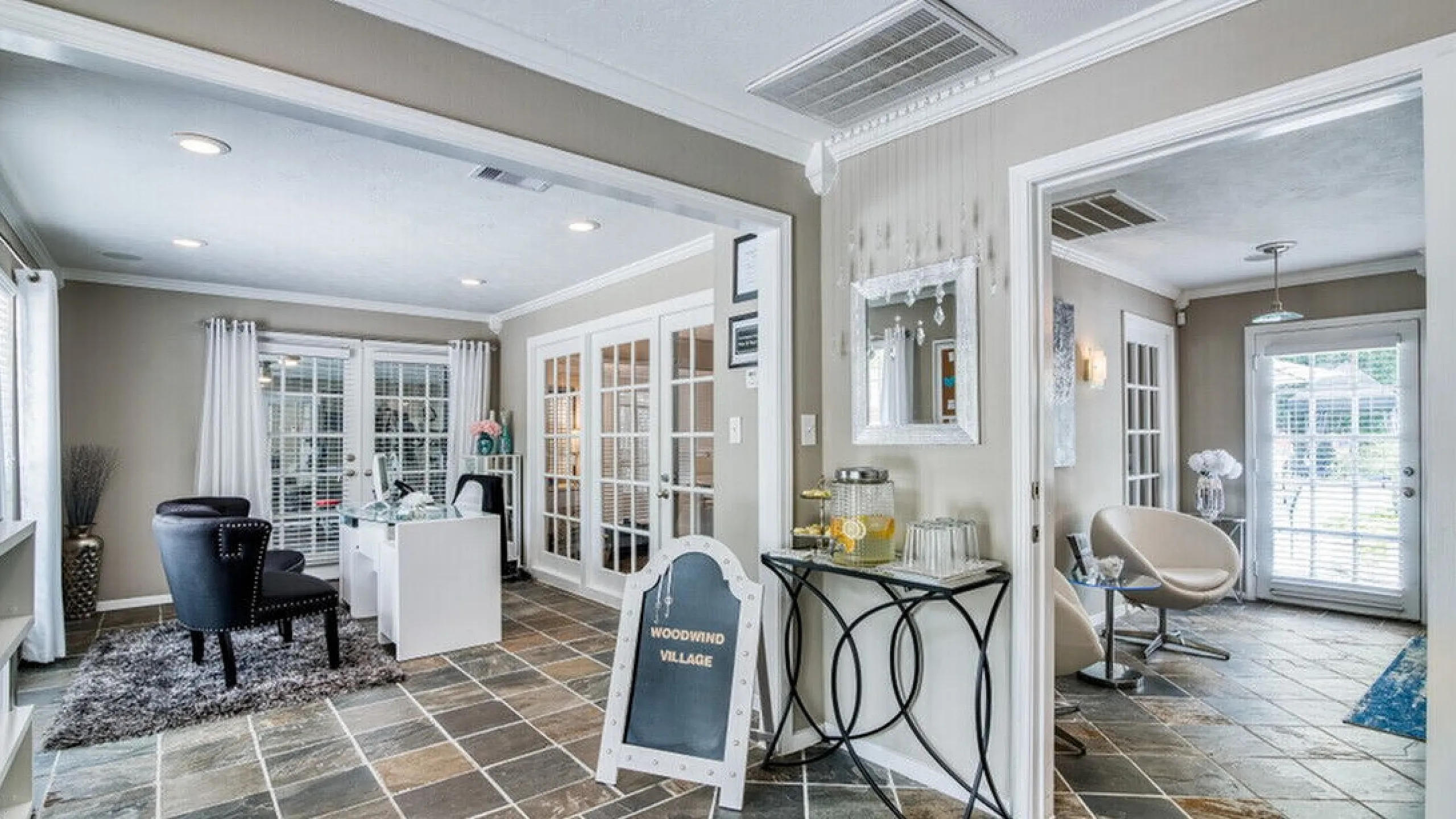 Elegant apartment interior showcasing stylish seating, modern decor, and abundant natural light through French doors.