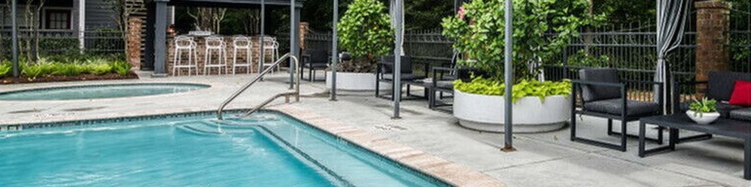 Luxurious outdoor pool area with stylish cabanas and lush greenery, offering a serene escape for relaxation and entertainment.