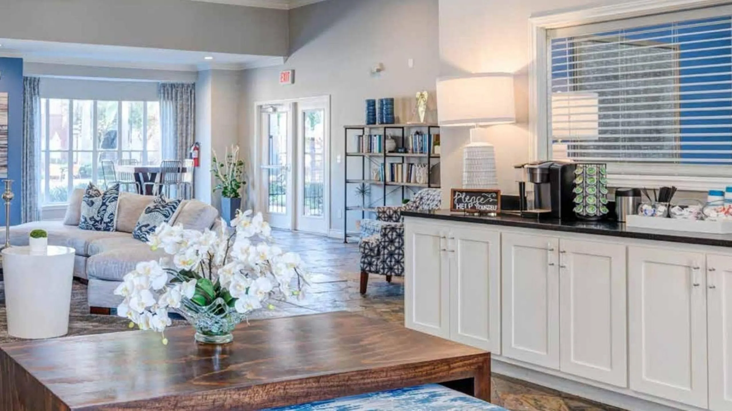 Luxurious open-concept apartment lobby with elegant seating, stylish decor, and a cozy coffee station.
