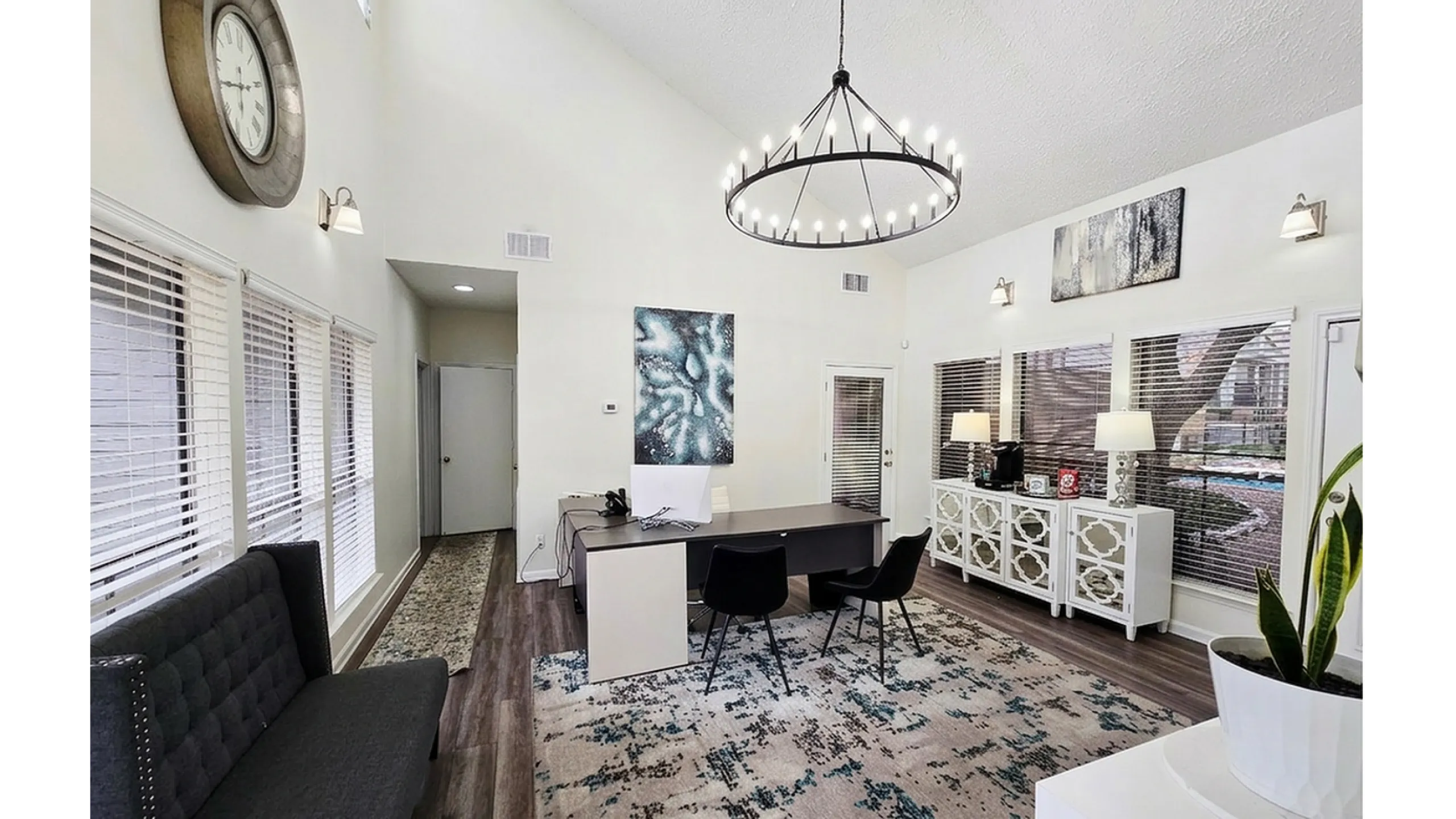 Bright and inviting office space with modern chandelier, stylish wall art, and elegant decor.