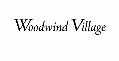 Elegant black script font displaying 'Woodwind Village' on a clean white background, offering a sense of sophistication and tranquility.