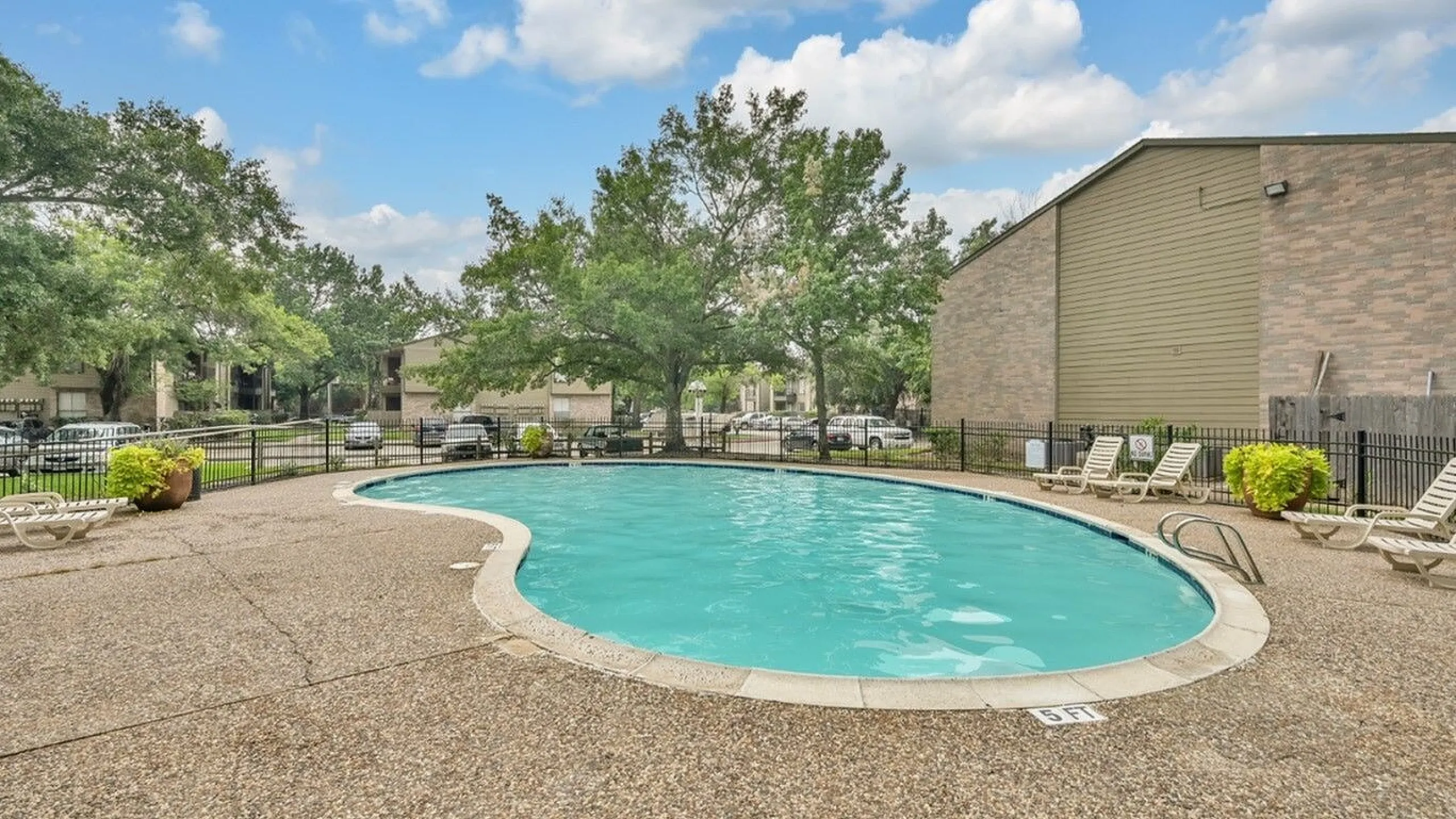 Inviting outdoor pool area surrounded by lush greenery and modern architecture, featuring comfortable sun loungers.