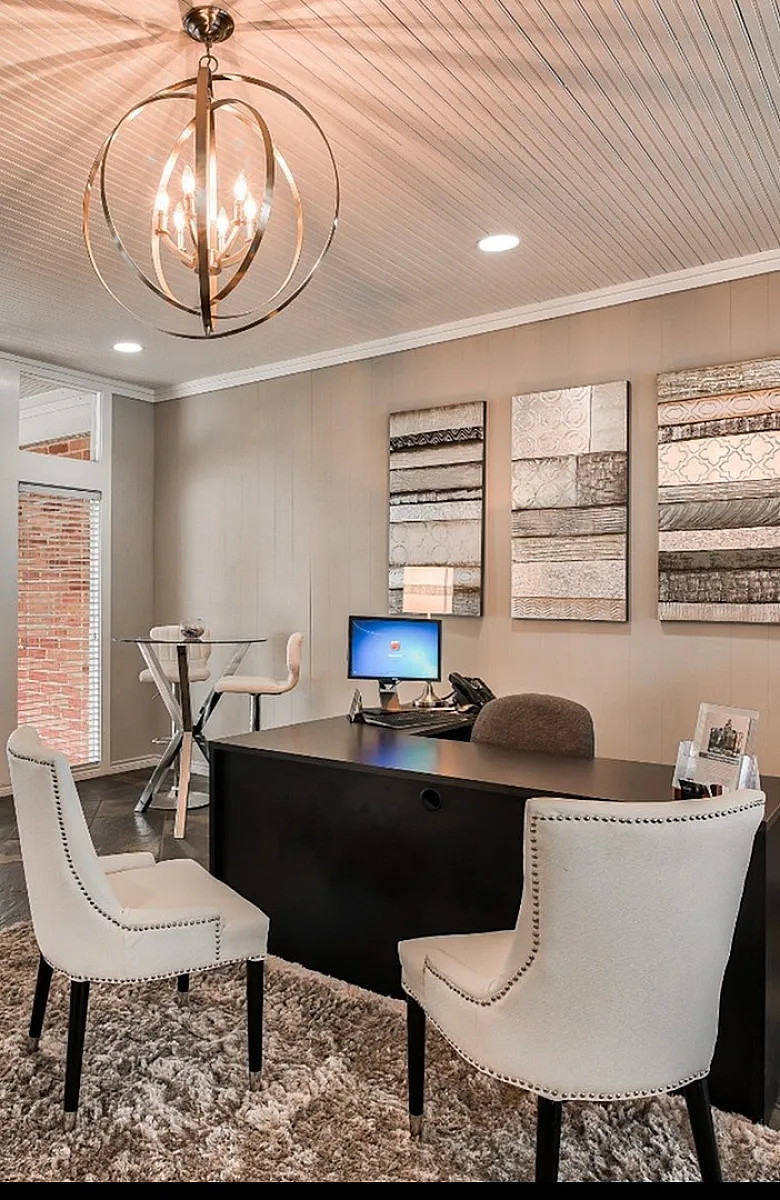 Elegant office interior with stylish chandelier, chic artwork, and plush carpet, showcasing modern design and comfort.