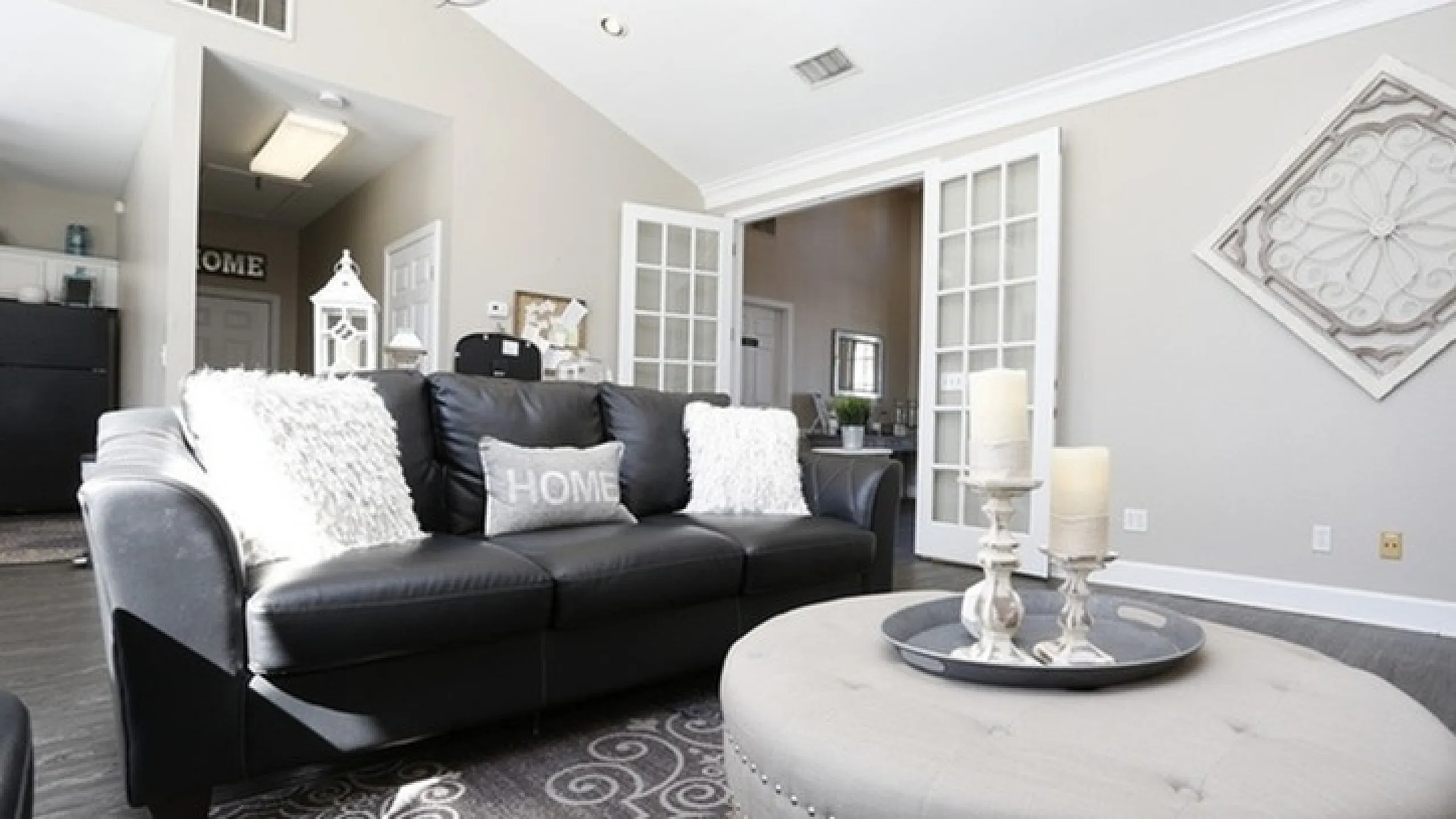 Elegant living room with plush black sofa, stylish decor, and soft lighting exuding a cozy home ambiance.