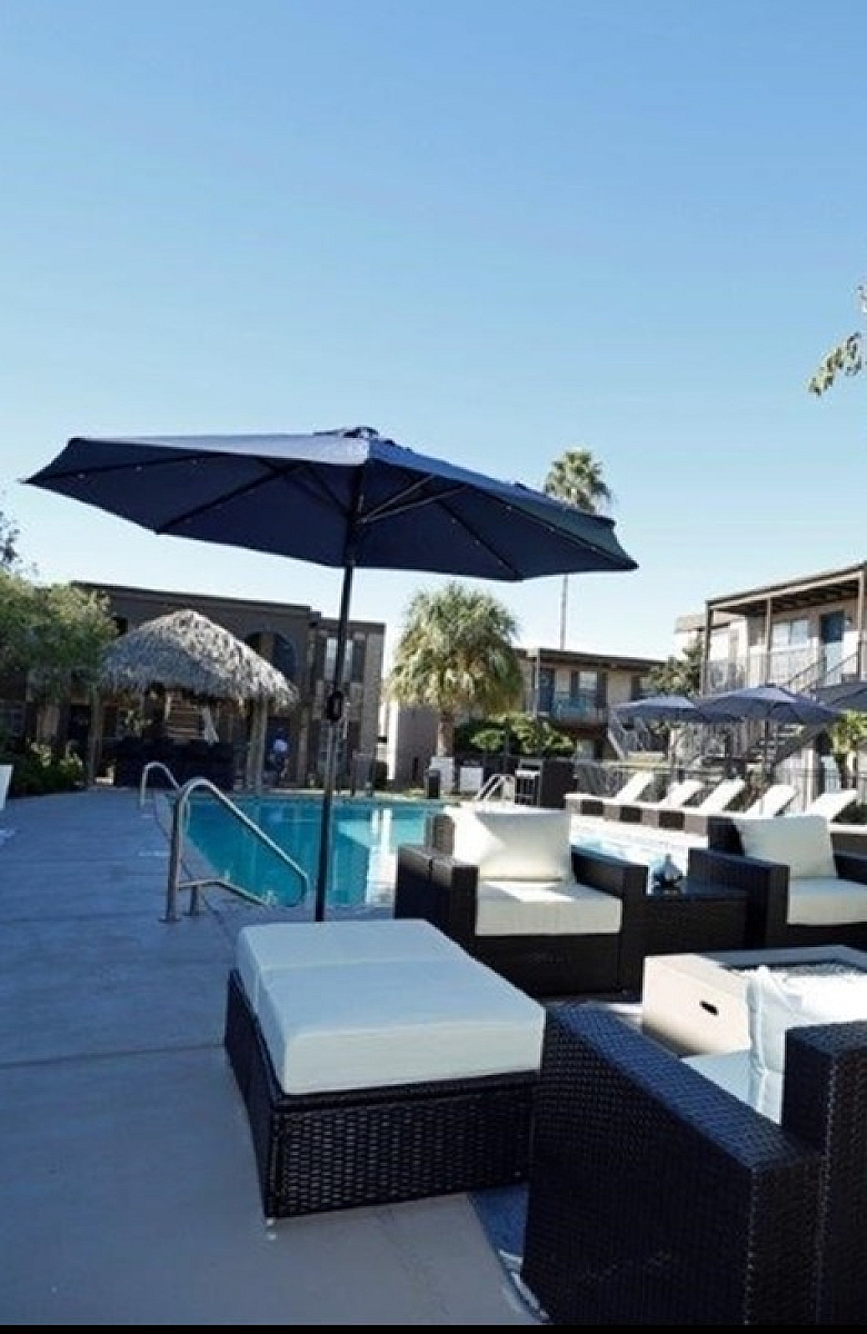 Luxurious outdoor pool area with stylish lounge seating and large umbrellas, perfect for relaxation and enjoyment.