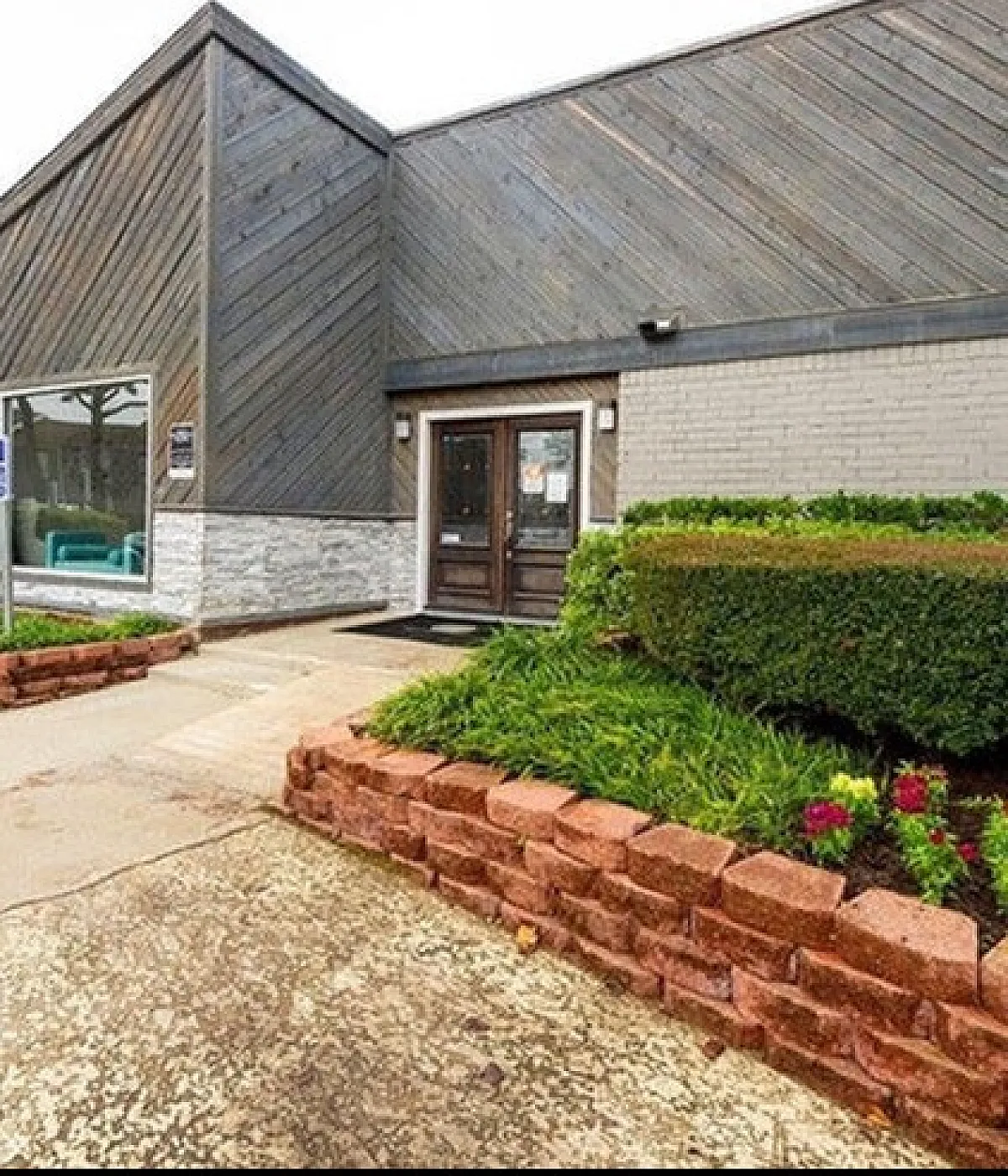 Elegant apartment entrance with modern architectural design, vibrant landscaping, and accessibility features.