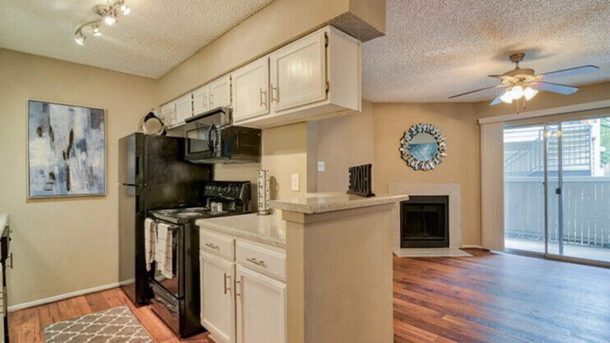 Inviting apartment featuring a modern kitchen with sleek appliances and a cozy living area with a fireplace and balcony access.