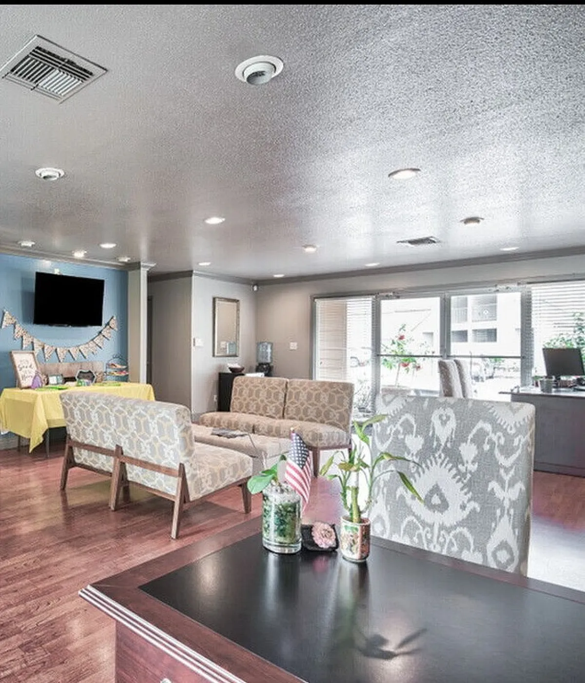 Inviting communal living space featuring cozy seating, elegant decor, and abundant natural light from large windows.