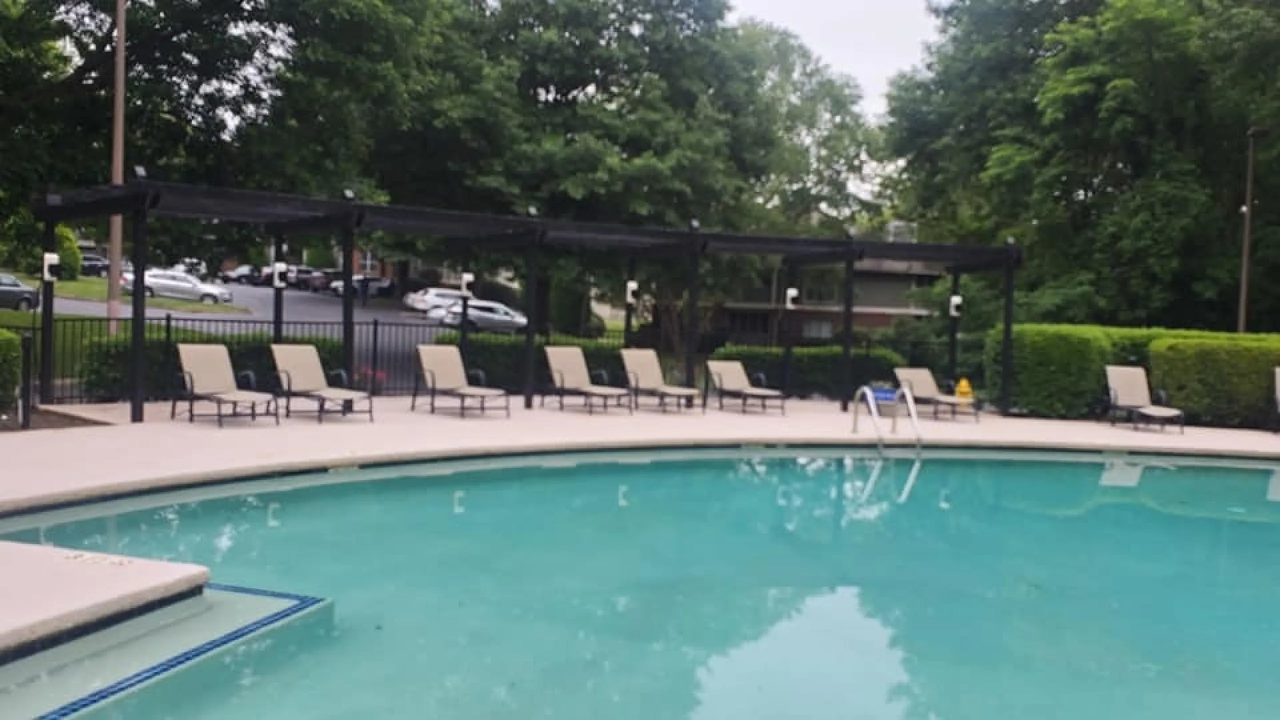 Inviting pool area with comfortable lounge chairs and lush green surroundings, perfect for relaxation and enjoyment.