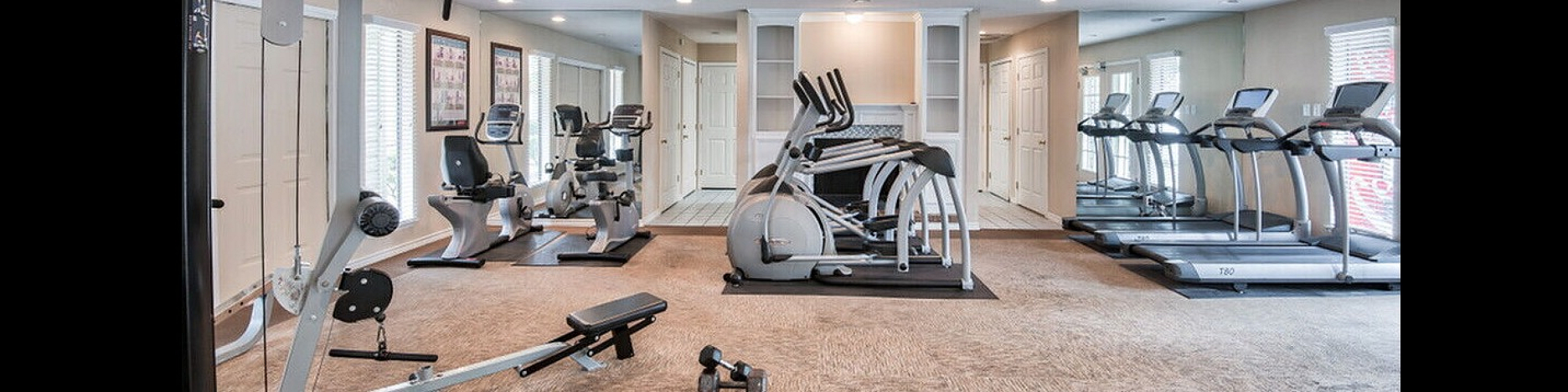 Bright and spacious fitness center featuring state-of-the-art exercise machines and mirrored walls for an optimal workout experience.