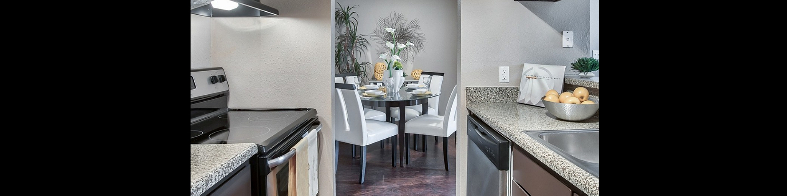 Modern kitchen leading to an elegant dining area with sleek white chairs, perfect for stylish entertaining.