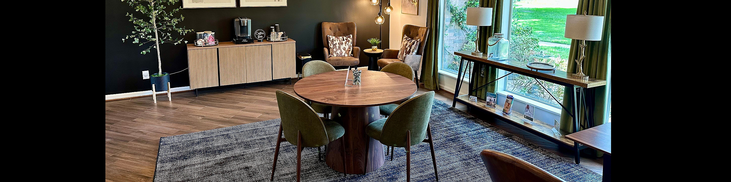 Chic, inviting lounge space with elegant modern decor, featuring a stylish dining area, sophisticated lighting, and large windows offering lush garden views.