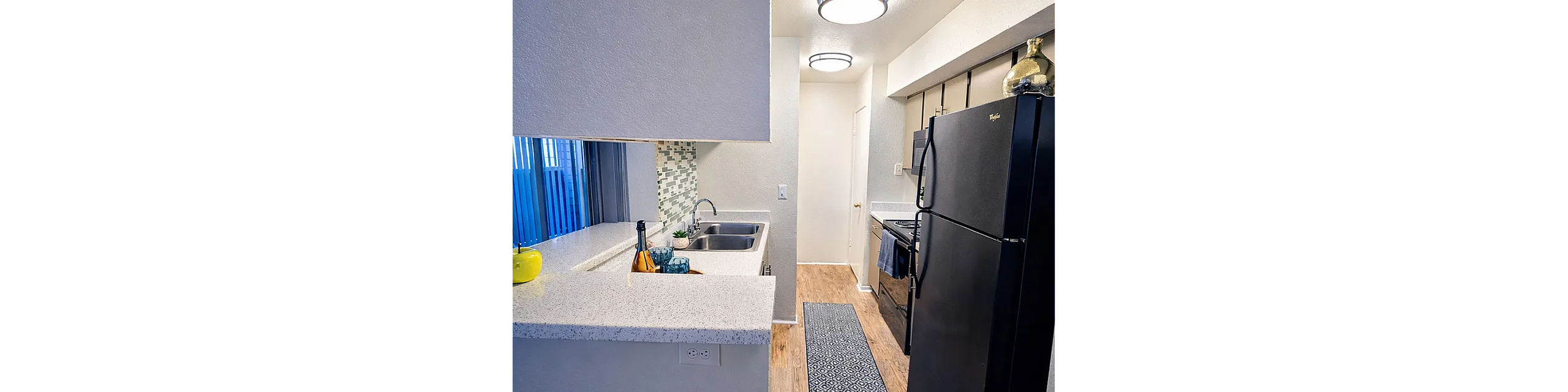 Modern kitchen with sleek black appliances, a spacious countertop, and vibrant backsplash tiles.