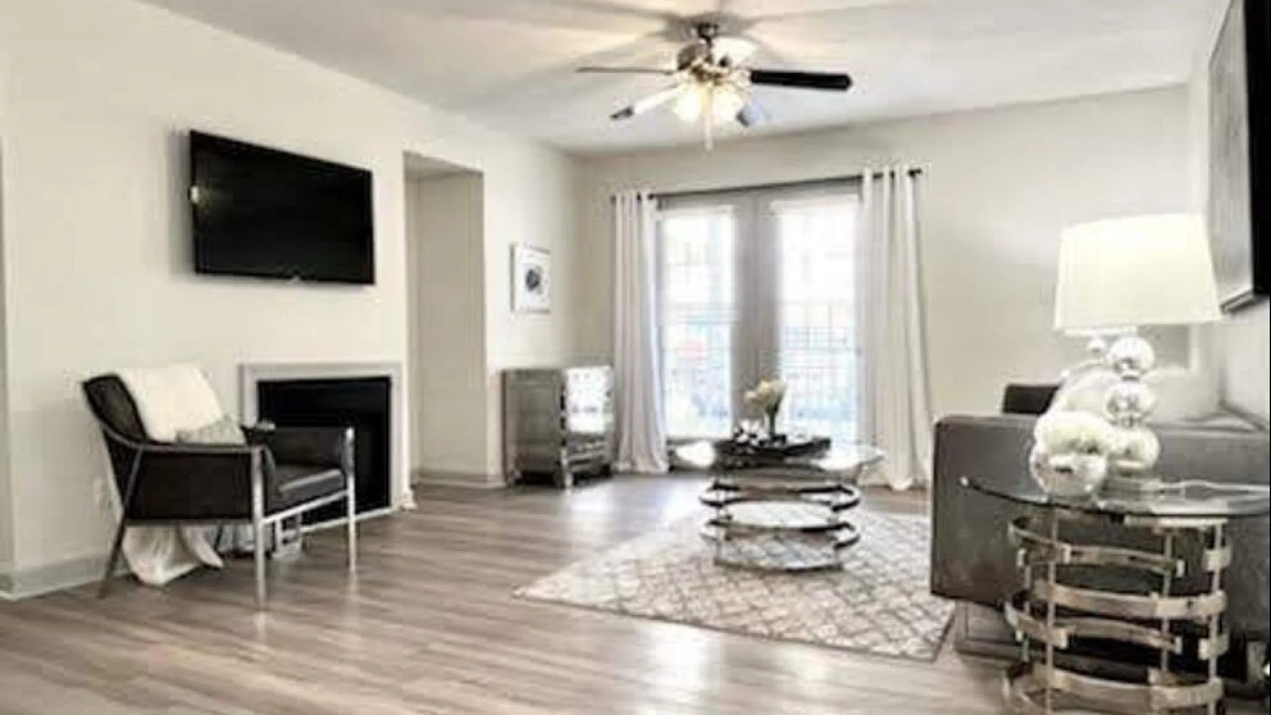 Modern living room with sleek hardwood floors, elegant decor, and ample natural light from large windows.