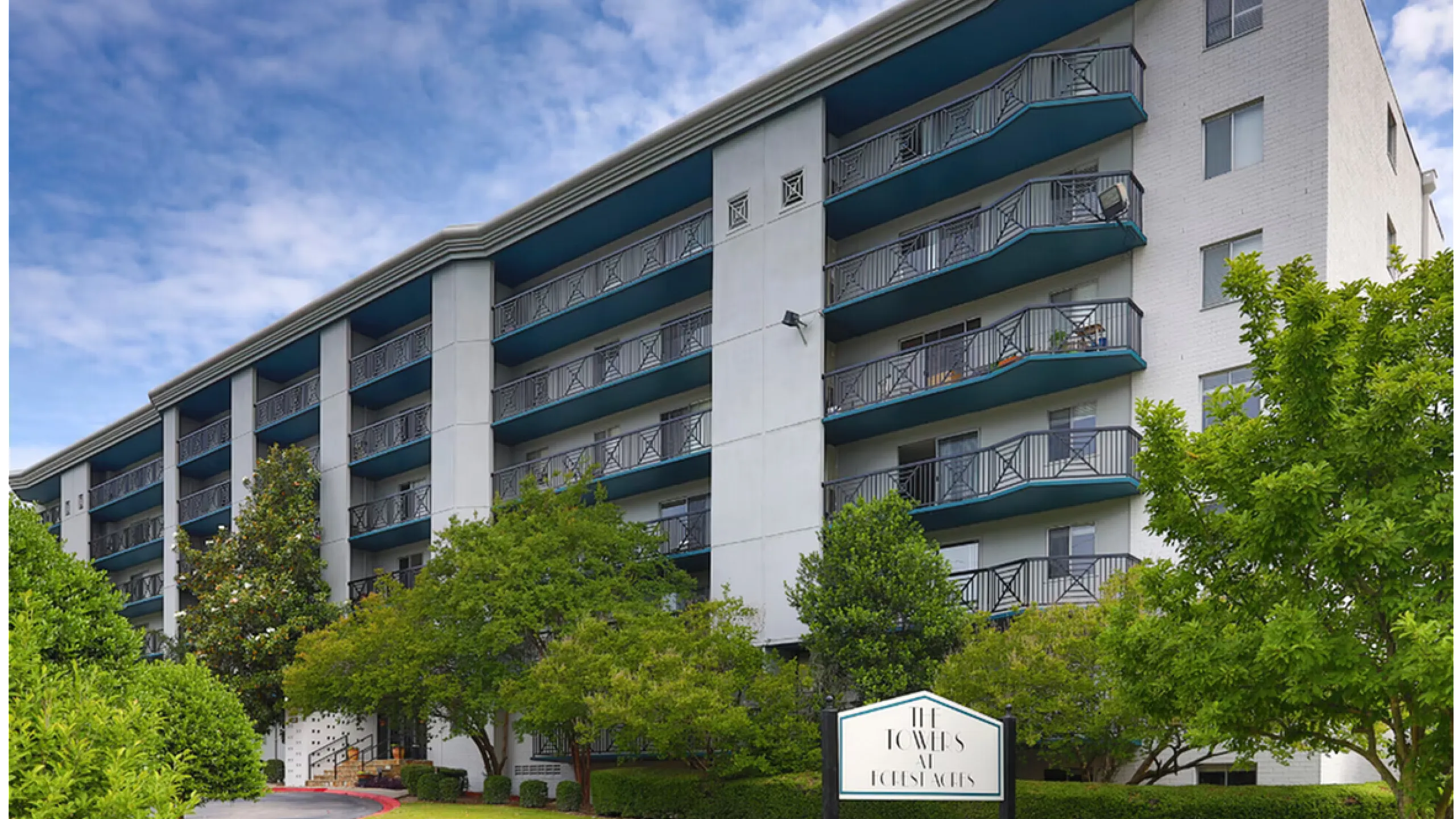 Contemporary multi-story apartment building with spacious balconies surrounded by lush greenery, showcasing a vibrant living environment.