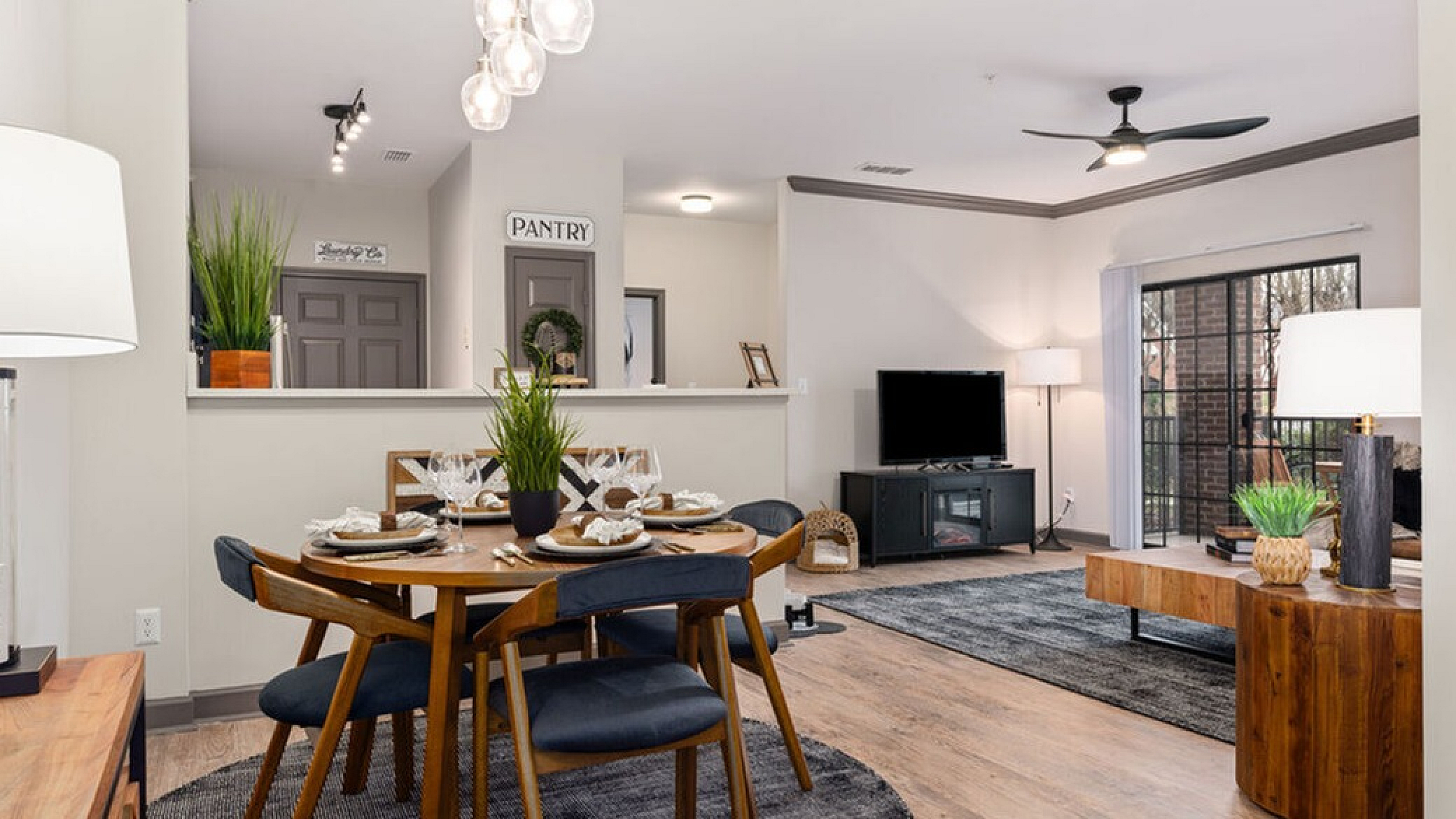 Elegant open-concept living and dining area with modern decor, featuring a stylish round dining table, cozy living room, and ample natural light.
