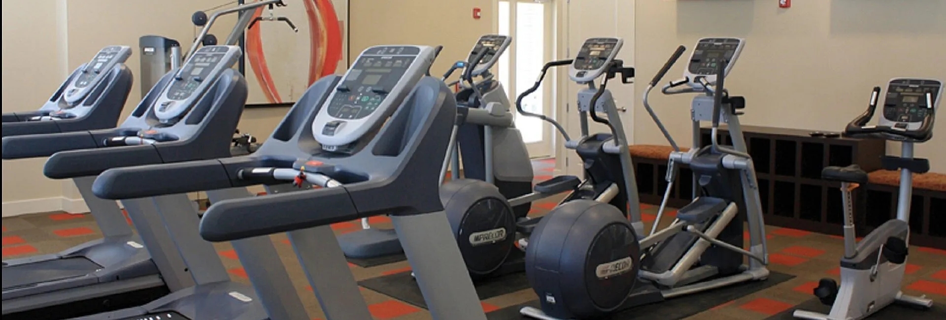 Modern fitness center equipped with state-of-the-art treadmills and exercise machines, offering a vibrant workout space.