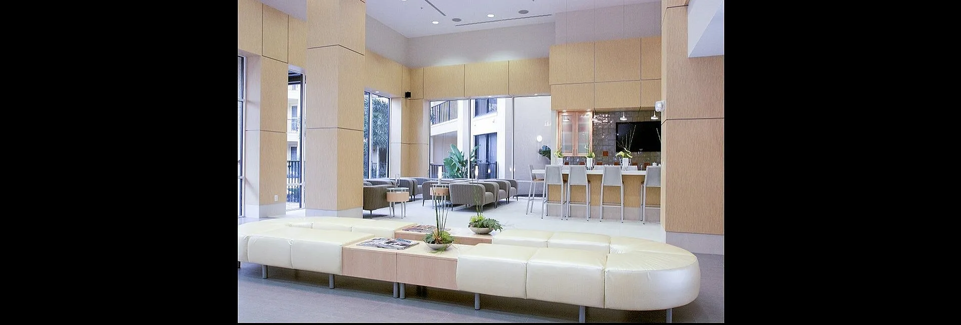 Elegant modern lounge area with sleek furniture, large windows, and spacious seating, perfect for relaxation and social gatherings.
