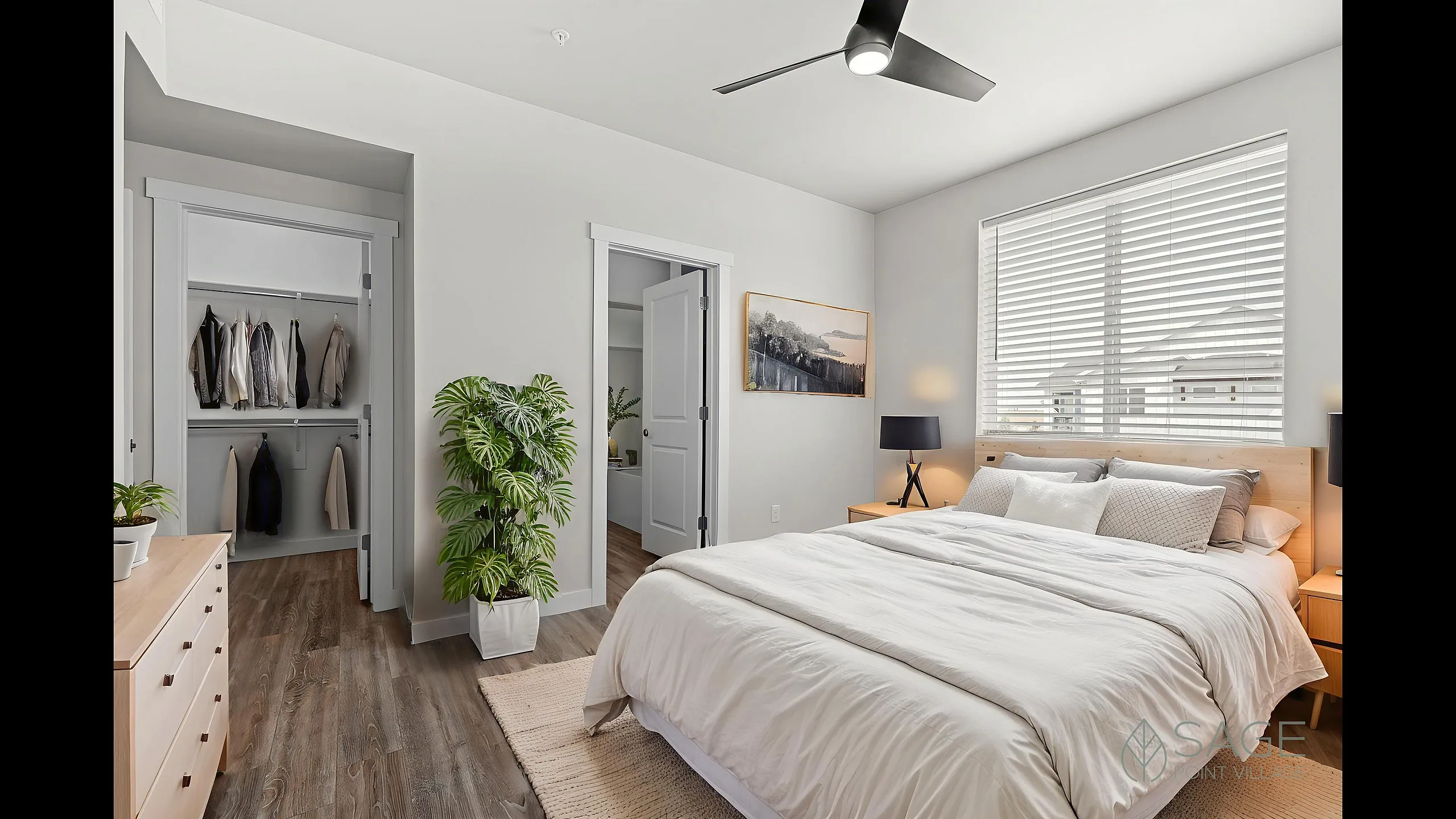 Bright and cozy bedroom with elegant decor, featuring a spacious bed, stylish wooden dresser, open wardrobe, and a lush indoor plant.