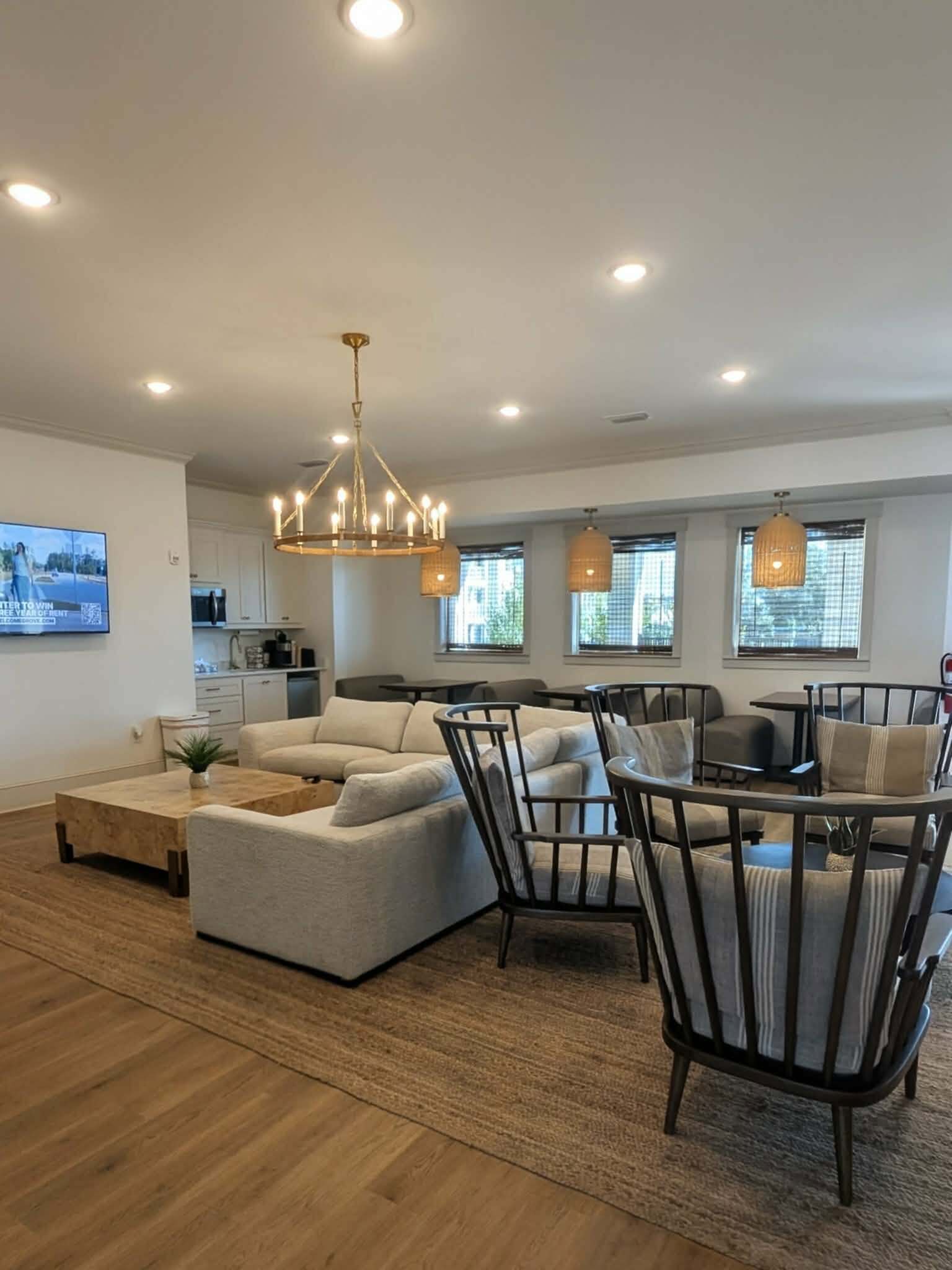 Elegant open-plan living area with modern decor, featuring a plush sectional sofa, chic lighting, and a cozy dining space with natural light.