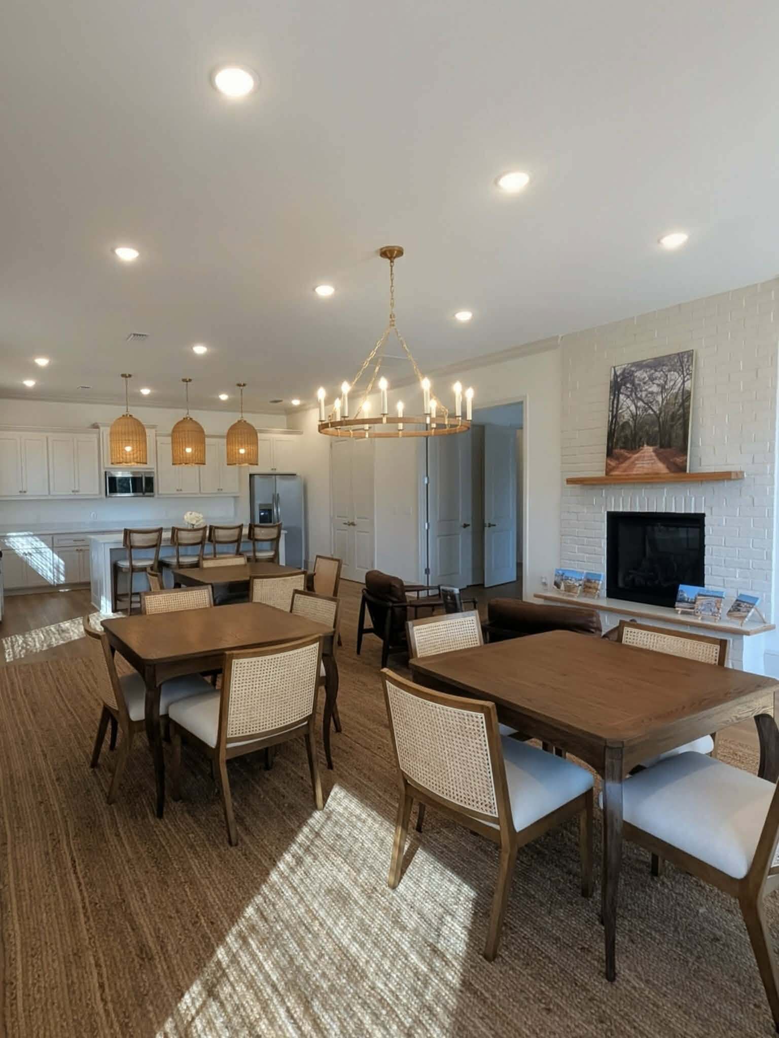 Elegant open-concept dining and kitchen area with chic lighting, modern furniture, and a cozy fireplace.