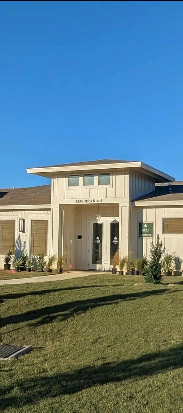 Charming modern building with sleek design, nestled in a landscaped area under a clear blue sky, ideal for a serene lifestyle.