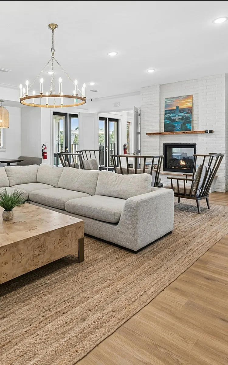 Chic and spacious living area boasting a cozy fireplace, elegant lighting, and modern furnishings, perfect for relaxation and entertainment.