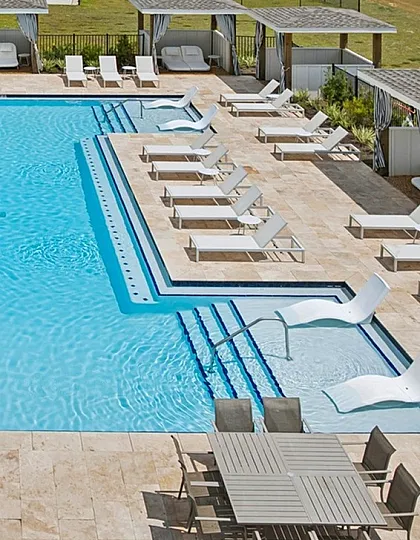Luxurious outdoor pool area with elegant lounge chairs, cozy cabanas, and a serene setting perfect for relaxation.