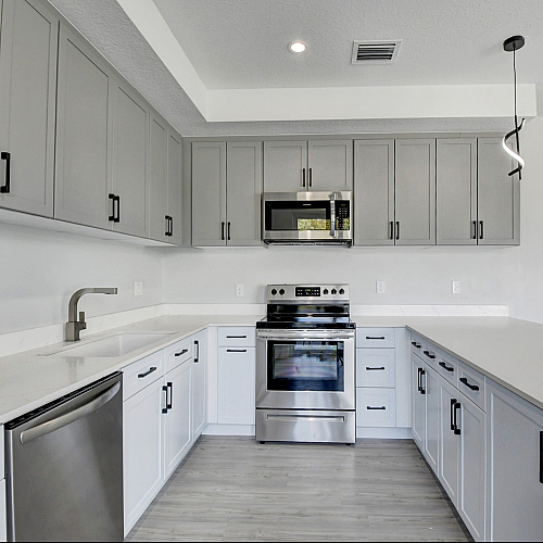Modern kitchen with sleek gray cabinetry, stainless steel appliances, and elegant countertops.
