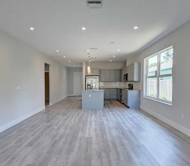 Gorgeous open-concept living area with elegant wooden flooring, modern recessed lighting, and a sleek kitchen with top-of-the-line appliances.